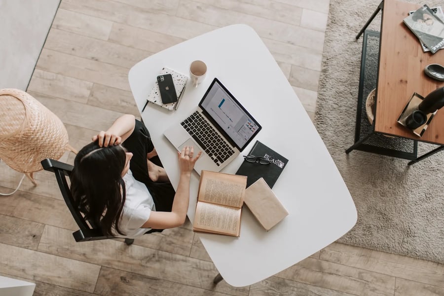 young-lady-using-laptop-at-table-in-modern-workspace-4050320